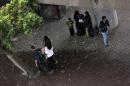 Egyptians take cover under a ramp as others walk on a street in the rain in Cairo, Egypt, Thursday, May 8, 2014. (AP Photo/Khalil Hamra)