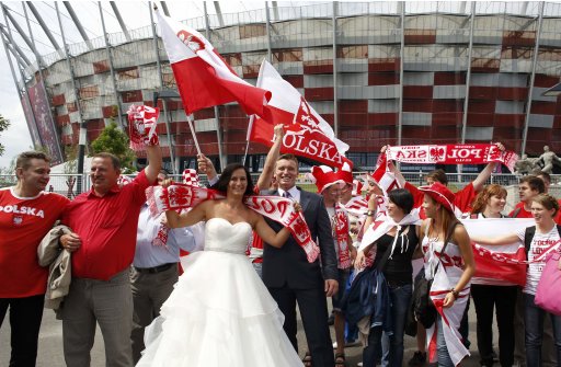 Just married Polish soccer fans pose outside a soccer stadium, venue of Euro 2012 soccer championships in Warsaw