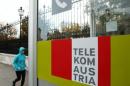 A jogger runs by a Telekom Austria phone booth in Vienna