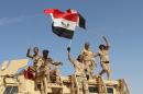 Iraqi government forces wave their national flags on March 10, 2016 after retaking the town of Zankura, northwest of Ramadi, from the Islamic State jihadist group