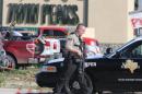 FILE - In this May 17, 2015 file photo, authorities investigate a shooting in the parking lot of the Twin Peaks restaurant, in Waco, Texas. Six witnesses say they heard a few pistol shots before automatic fire took over during a shootout last month at a Waco Twin Peaks restaurant. Police have acknowledged firing on armed bikers, but say they cannot address how many of the nine dead and 18 wounded were shot by bikers and how many were shot by officers. (AP Photo/Jerry Larson, File)