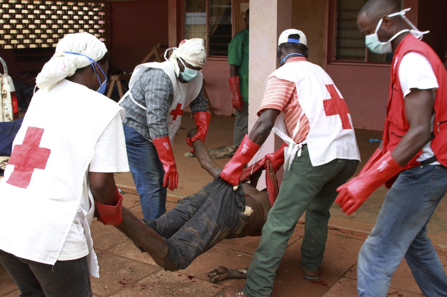 Red Cross workers carry a dead body into a morgue during violence between Muslim and Christian militias in Bangui