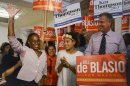 Chirlane McCray, the wife of New York mayoral candidate Bill de Blasio (R), waves after being introduced while attending a campaign rally with their daughter Chiara (C) in Brooklyn, New York