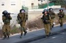 Israeli soldiers run during clashes with Palestinian protesters in Betunia on September 27, 2013