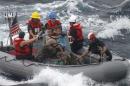 Sailors assist in the rescue of a family with a sick infant via the ship's small boat as part of a joint U.S. Navy, Coast Guard and California Air National Guard rescue effort