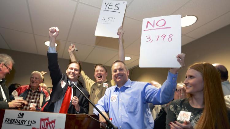 State Sen. Charlie Jansssen of Fremont, third left, Jeremy Jensen, center, and John Wiegert, second right, celebrate in Fremont, Neb., Tuesday, Feb. 11, 2014, after city voters have decided by voting no, to uphold the law designed to bar immigrants from renting homes if they don’t have legal permission to be in the U.S. (AP Photo/Nati Harnik)