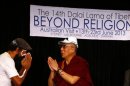 Tibetan spiritual leader the Dalai Lama responds with a traditional salutation known as a "namaste" as Australian Aboriginal man approaches him during a media conference in Sydney