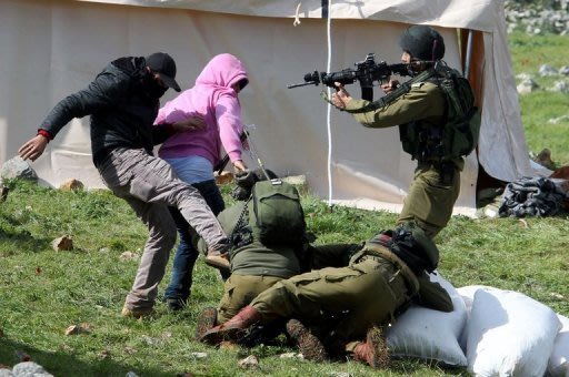 Manifestantes palestinos resistem ao serem detidos por soldados israelenses perto de Burin, na Cisjordânia