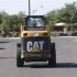 A worker drives a Caterpillar tractor near a construction site in Gilbert
