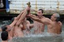 Swimmers celebrate together after Lukas Kokinis from Greece, second right, retrieved a wooden cross which was thrown into the waters by Ecumenical Patriarch Bartholomew I during a ceremony to bless the water at the Golden Horn in Istanbul, Turkey, Sunday, Jan. 6, 2013. The traditional ceremony marks the Epithany in Istanbul, Turkey, when an Orthodox priest throws a wooden cross into the water and swimmers race to be the first to retrieve it. (AP Photo)