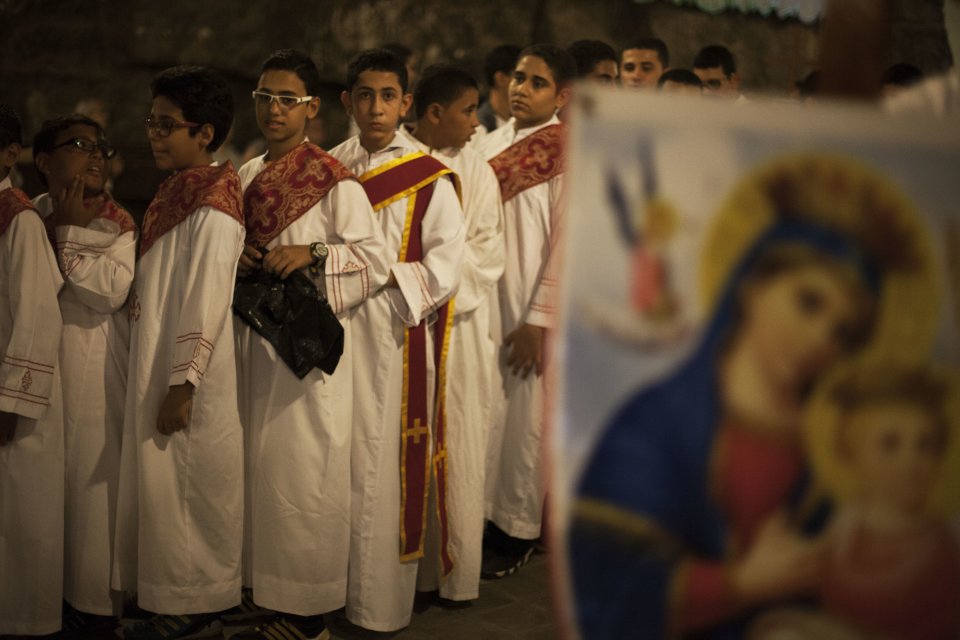 Egyptian youths line up before a procession at Al-Mahraq monastery in Assiut, Upper Egypt, Tuesday, Aug. 6, 2013. Islamists may be on the defensive in Cairo, but in Egypt's deep south they still have much sway and audacity: over the past week, they have stepped up a hate campaign against the area's Christians. Blaming the broader Coptic community for the July 3 coup that removed Islamist president Mohammed Morsi, Islamists have marked Christian homes, stores and churches with crosses and threatening graffiti. (AP Photo/Manu Brabo)
