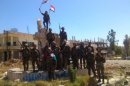This photo released by the Syrian official news agency SANA, shows Syrian army troops hold up national flags in the town of Qusair, near the Lebanon border, Homs province, Syria, Wednesday, June 5, 2013. The Syrian army triumphantly announced Wednesday the capture of a strategic town near the Lebanese border, telling the nation it has "cleansed" the rebel-held Qusair of "terrorists" fighting President Bashar Assad's troops. The capture of the town, which lies close to the Lebanese border, solidifies some of the regime's recent gains on the ground that have shifted the balance of power in Assad's favor in the Syrian civil war. (AP Photo/SANA)