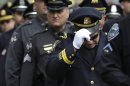 A Revere, Mass. police captain holds his cap while entering a memorial service for fallen Massachusetts Institute of Technology police officer Sean Collier, in Cambridge, Mass., Wednesday, April 24, 2013. Collier was fatally shot on the MIT campus Thursday, April 18, 2013. Authorities allege that the Boston Marathon bombing suspects were responsible. (AP Photo/Steven Senne)