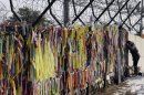 A man looks through the wire fence covered with ribbons carrying messages of people's wish for the reunification of the two Koreas at the Imjingak Pavilion near the border village of Panmunjom, which has separated the two Koreas since the Korean War, in Paju, north of Seoul, South Korea, Wednesday, Feb. 13, 2013. Defying U.N. warnings, North Korea on Tuesday conducted its third nuclear test in the remote, snowy northeast, taking a crucial step toward its goal of building a bomb small enough to be fitted on a missile capable of striking the United States. (AP Photo/Lee Jin-man)