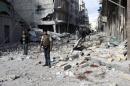 Syrians stand in a destroyed street following a reported airstrike by government forces on the northern city of Aleppo, on January 28, 2014