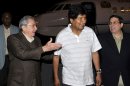 In this picture released by the Cuban newspaper Juventud Revelde, Bolivia's President Evo Morales, center, is welcomed by Cuba's President Raul Castro, left, and Cuba's Foreign Minister Bruno Rodriguez at the Jose Marti international airport in Havana, Cuba, early Sunday, Dec. 23, 2012. Evo Morales is in Cuba to visit Venezuela's President Hugo Chavez, who is recovering from a surgery, his fourth operation related to his pelvic cancer since June 2011. (AP Photo/Juventud Revelde, Estudios Revolucion)