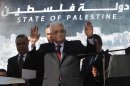 FILE - In this Dec. 2, 2012 file photo, Palestinian President Mahmoud Abbas waves to the crowd during celebrations for their successful bid to win U.N. statehood recognition. Palestinian officials said Monday Jan. 7, 2013, they will not rush to issue new passports and ID cards with the emblem "State of Palestine" to avoid confrontation with Israel. Last week, Palestinian President Mahmoud Abbas decreed that in official documents "State of Palestine" must replace "Palestinian Authority," the name of his self-rule government. (AP Photo/Nasser Shiyoukhi, File)