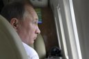 Russian President Vladimir Putin looks out of a helicopter window during his visit to Russia's far eastern Sakhalin region July 16, 2013. REUTERS/Aleksey Nikolskyi