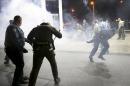 Police try to control a crowd Wednesday, Dec. 24, 2014, on the lot of a gas station following a shooting Tuesday in Berkeley, Mo. St. Louis County police say a man who pulled a gun and pointed it at an officer has been killed. (AP Photo/St. Louis Post-Dispatch, David Carson)