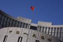 A Chinese national flag flutters outside the headquarters of the People's Bank of China in Beijing