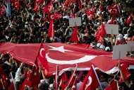 Supporters of Turkish Prime Minister Recep Tayyip Erdogan carry a large Turkish flag during his speech in Ankara, Turkey, Sunday, June 9, 2013.(AP Photo/Vadim Ghirda)