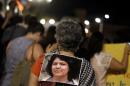 An activist carries a photo of slain environmental rights activist Berta Caceres on her back during a protest to mark International Women's Day in San Jose