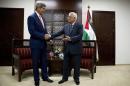 Palestinian President Mahmoud Abbas invites U.S. Secretary of State John Kerry to take a seat for their meeting in the West Bank city of Ramallah