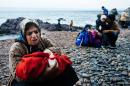 An elderly woman sings a lullaby to baby on a beach after arriving with other migrants and refugees on the Greek island of Lesbos after crossing the Aegean sea from Turkey on October 11, 2015