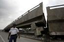 An officer walks beside a collapsed bridge after an earthquake struck off the Pacific coast, in Guayaquil