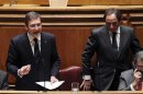 Portugal's Prime Minister Pedro Passos Coelho reacts near Foreign Affairs Minister Paulo Portas at the parliament in Lisbon