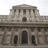 Pedestrians walk past the Bank of England in the City of London
