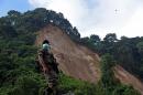 A soldier stands guard at the site where a landslide took place in the village of El Cambray II, in Santa Catarina Pinula municipality, some 15 km east of Guatemala City, on October 6, 2015