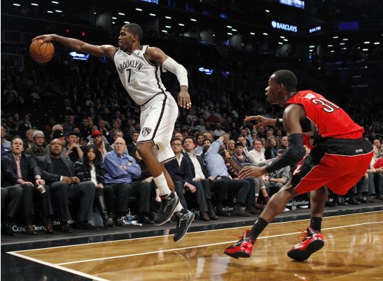 Brooklyn Nets guard Joe Johnson saves a ball from going out of bounds in front of Toronto Raptors guard Terrence Ross in the fourth quarter of their NBA basketball game in New York