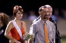 Whitney Kropp is escorted by her father, Jason Kropp onto the Ogemaw Heights High School football field Friday night, Sept. 28, 2012, in West Branch, Mich. Kropp was named to the homecoming court of the 800-student school earlier this month, but said she felt betrayed after some students suggested her selection was a joke. (AP Photo/Detroit News, John M. Galloway) DETROIT FREE PRESS OUT; HUFFINGTON POST OUT