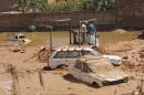 Algerian residents check a flood-damaged vehicle on October 3, 2008 in Ghardaia, south of Algiers
