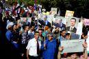 This photo released by the Syrian official news agency SANA, shows Syrians holding photos of Syrian President Bashar Assad and Russian President Vladimir Putin, during a rally to thank Moscow for its intervention in Syria, in front of the Russian embassy in Damascus, Syria, Tuesday, Oct. 13, 2015. Insurgents fired two shells at the Russian embassy in the Syrian capital on Tuesday as hundreds of pro-government supporters gathered outside the compound to thank Moscow for its intervention in Syria. The placard at right with Arabic reads, 