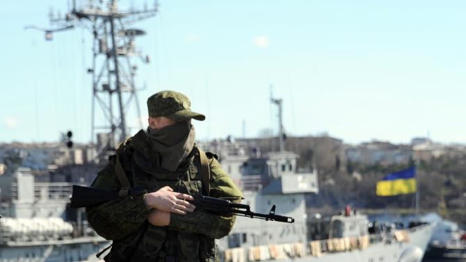 A member of the Russian troops stands guard near a Ukrainian navy ship in the harbor of Sevastopol on March 5, 2014