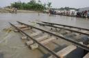 People look at rail tracks damaged by flood waters near the Balashi rail station in Gaibandha