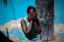 Marieline Jean covers her face with her hands as she poses for a portrait at the house where she lives in Port-au-Prince, Haiti