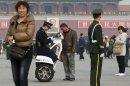 In this photo taken Nov. 2, 2012, a Chinese police officer checks the identity card of a visitor on Tiananmen Square in Beijing. Authorities want no more surprises as party leaders convene in the capital, and rights groups say the wide-ranging crackdown on critics bodes poorly for those who hope the incoming generation of leaders will loosen restrictions on activism. (AP Photo/Andy Wong)
