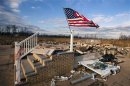 A U.S. flag flies over the foundation of a home destroyed by the storm surge of superstorm Sandy in the Staten Island borough neighborhood of Oakwood