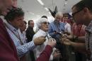 Bernie Ecclestone, center, president and CEO of Formula One Management, center, answers to reporters in the newsroom ahead the the Bahrain Formula One Grand Prix at the Bahrain International Circuit in Sakhir, Bahrain, Sunday, April 6, 2014. (AP Photo/Luca Bruno)