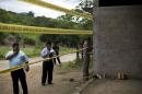 FILE - In this July 3, 2014 file photo, state authorities use crime scene tape to seal off an unfinished warehouse that was the site of a shootout between Mexican soldiers and alleged criminals on the outskirts of the village of San Pedro Limon in Mexico state, Mexico. The Federal Judiciary Council said Friday, Nov. 7, 2014 a Mexican judge ordered seven soldiers to stand trial in the killing of suspected gang members after they were subdued, the latest chapter in the government's tardy recognition that executions occurred at a grain warehouse in southern Mexico on June 30. The charges did little to resolve the mystery of how many of the 22 purported gang members killed that day after a gunbattle were executed by soldiers and how many soldiers were actually involved. (AP Photo/Rebecca Blackwell, File)
