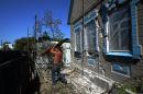 A man repairs the damages caused to his house in Yasinuvata, on the outskirts of Donetsk, on September 6, 2014