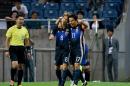 Japanese forward Genki Haraguchi (C) celebrates with captain Makoto Hasebe after scoring the opening goal against Iraq during a World Cup qualifier in Saitama on October 6, 2016