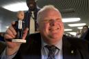 FILE - In this Tuesday, Nov. 12, 2013 file photo, Toronto Mayor Rob Ford holds a bobblehead doll depicting him at Toronto City Hall. An electoral map of the 2010 mayoral election shows that Ford's voter base resides mainly in a more conservative constituency than the downtown electorate. (AP Photo/The Canadian Press, Frank Gunn)