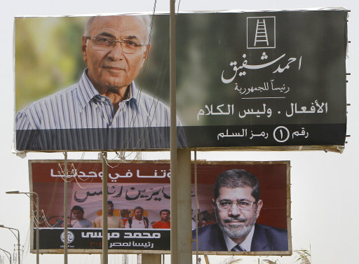 Giant billboards showing Egyptian presidential candidates  Ahmed Shafiq, top, and Mohammed Morsi, bottom, are seen along a highway in Cairo, Egypt, Monday, June 11, 2012.  Shafiq, the last prime minister of deposed President Hosni Mubarak, will face the Muslim Brotherhood's candidate, Mohammed Morsi, in a runoff on June 16-17. Arabic sign, top, reads, 