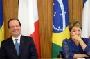 French President Francois Hollande (L) and Brazilian President Dilma Rousseff laugh during a ceremony at Planalto Palace in Brasilia on December 12, 2013