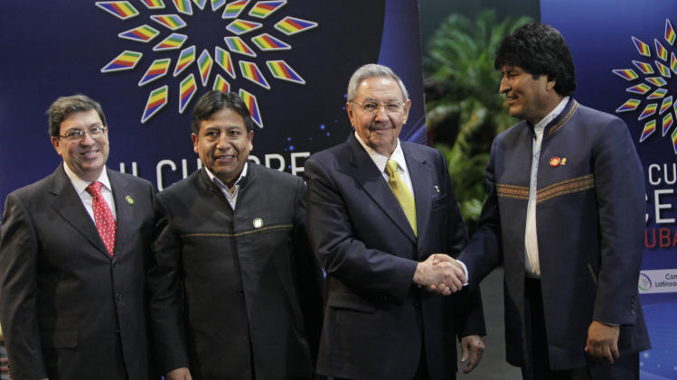 Cuba's President Raul Castro, second from right, shakes hands with Bolivia's President Evo Morales at the CELAC Summit in Havana, Cuba, Tuesday, Jan. 28, 2014. Bolivia's Foreign Minister David Choquehuanca stands second from left and Cuba's Foreign Minister Bruno Rodriguez Parrilla stands at far left. Leaders from Latin America and the Caribbean are in Cuba to talk about poverty and inequality at a summit of a regional bloc formed as a force for integration and a counterbalance to the U.S. (AP Photo/Cubadebate, Ismael Francisco)