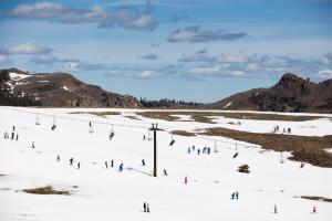 Skiers slalom past patches of dry ground at Squaw Valley &hellip;